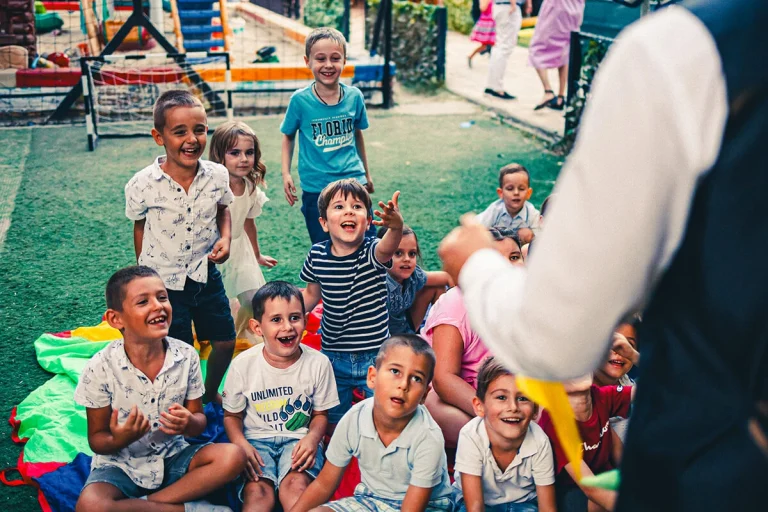 srecna deca na rodjendanu gledaju madjionicarsku predstavu sa sjajnim trikovima